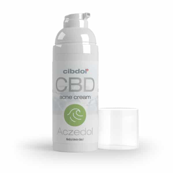 En flaske Zemadol CBD creme ved siden af et glas.