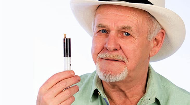 en mand i en hvid hat med en cigaret.
