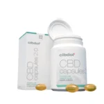 En flaske og æske Cibdol 5% CBD Softgel Capsules 2.0 (60 stk – 8,3 mg) med flere kapsler spredt rundt omkring.